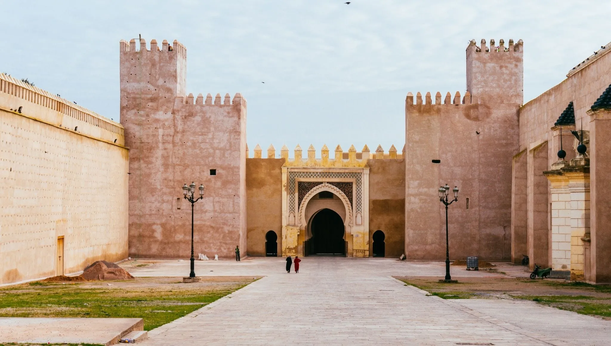 Wide view of a fortified Moroccan city gate and walls near Fes, capturing the imperial-era architecture featured in a 2 days Fes itinerary.