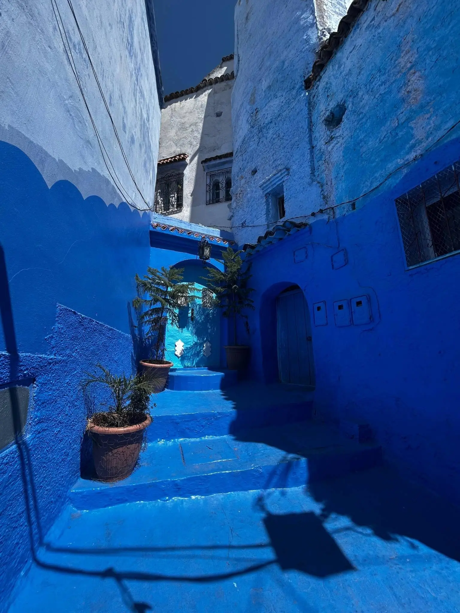 Narrow stairway and indigo walls in Chefchaouen’s medina—photogenic detour that may add a day or two to a Morocco itinerary.