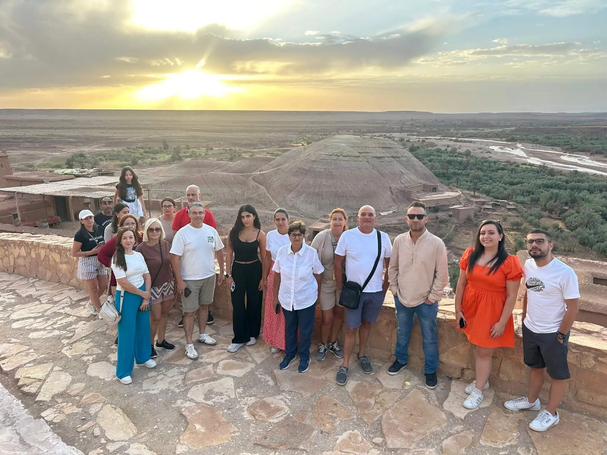 Tour group at a panoramic viewpoint overlooking the Ounila Valley and Aït Benhaddou ksar during a 7-day Morocco desert and Chefchaouen tour.