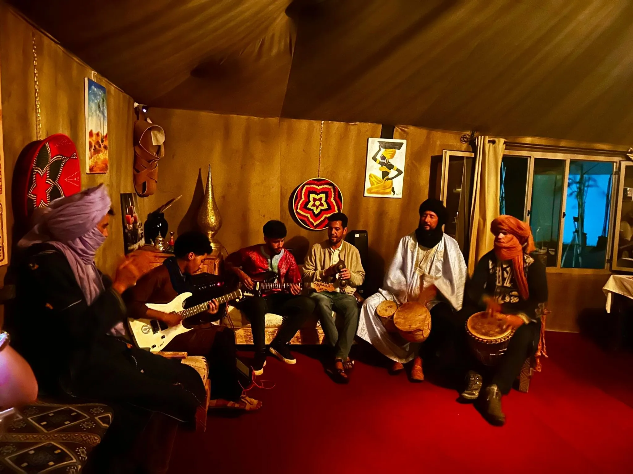 Berber musicians playing drums and guitar inside Sahara desert camp